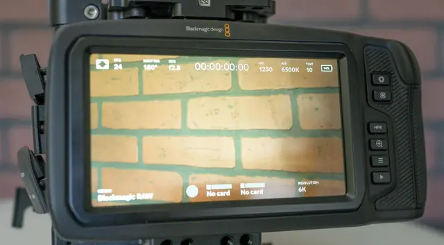 Écran tactile arrière de la Blackmagic Pocket 6K Pro affichant l'interface d'enregistrement, devant un mur de briques.